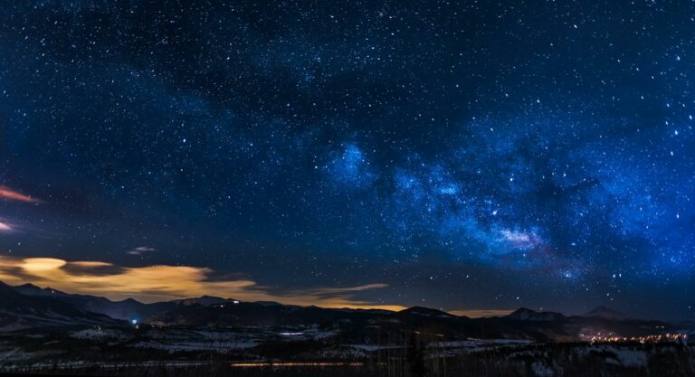 black mountains under the stars at nighttime