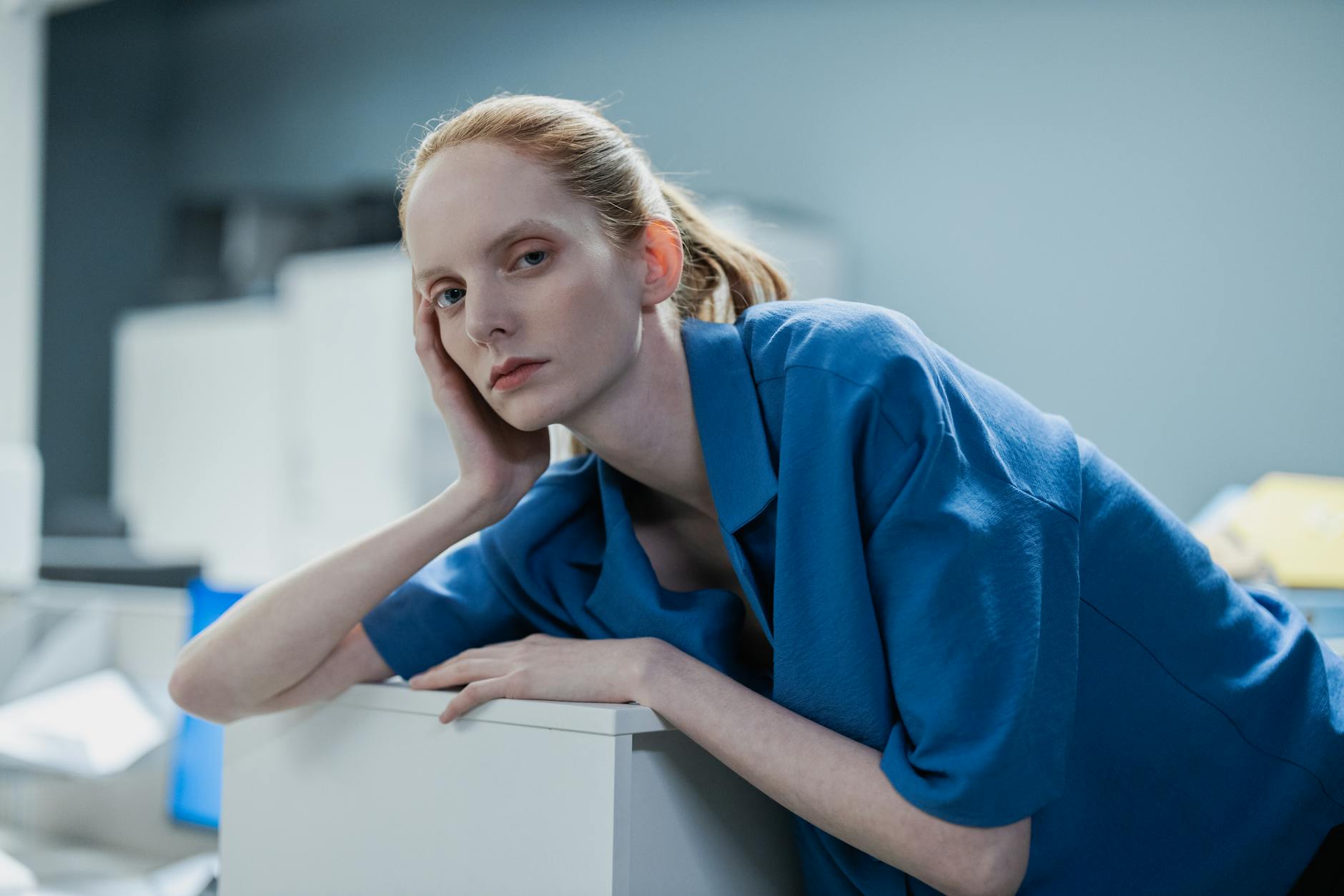 woman in blue polo shirt leaning on table